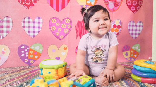 Baby on mat. Pink hearts background