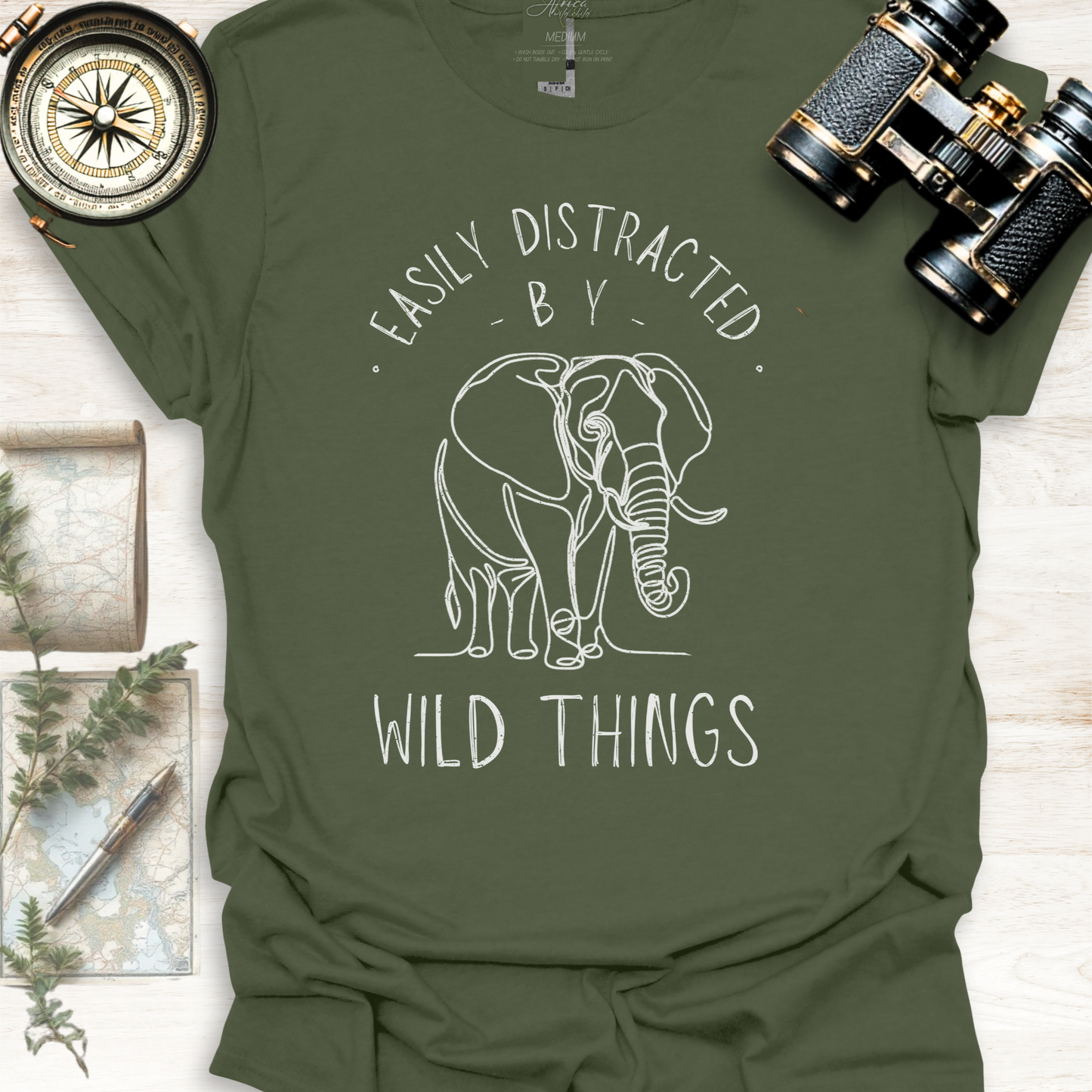 Military green wildlife graphic t-shirt with white elephant graphic and text 'Easily Distracted by Wild Things, outdoor lifestyle apparel by Africa Wild Child.