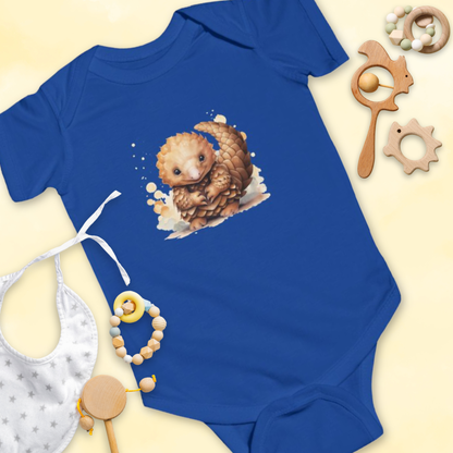 Blue baby onesie with a pangolin design, surrounded by baby items on a light yellow background.