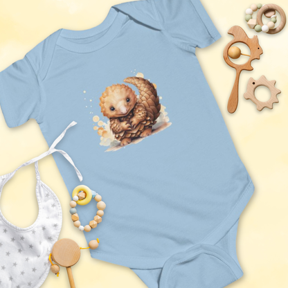 Light blue baby onesie with a pangolin design, surrounded by baby items on a light yellow background.