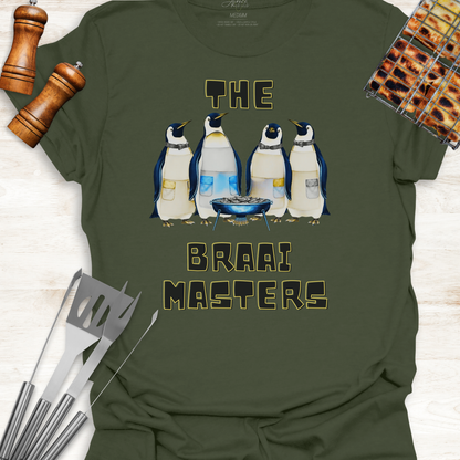 Green t-shirt with penguin design and 'The Braai Masters' text on a wooden surface with grill tools.